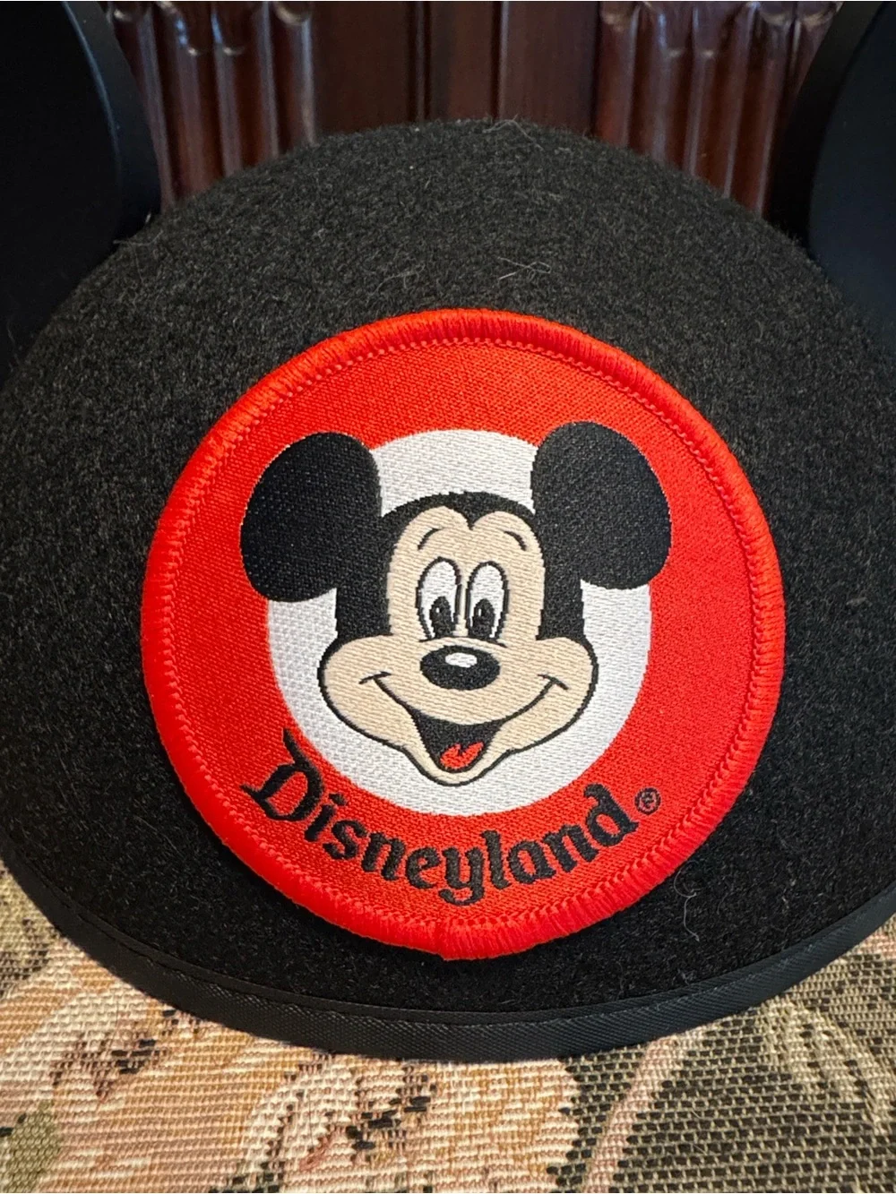 Disney black Mickey Mouse ears hat with red patch.
